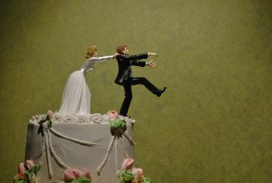 bride figure pushing groom figure off top of wedding cake