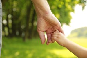 small child holding parents hand