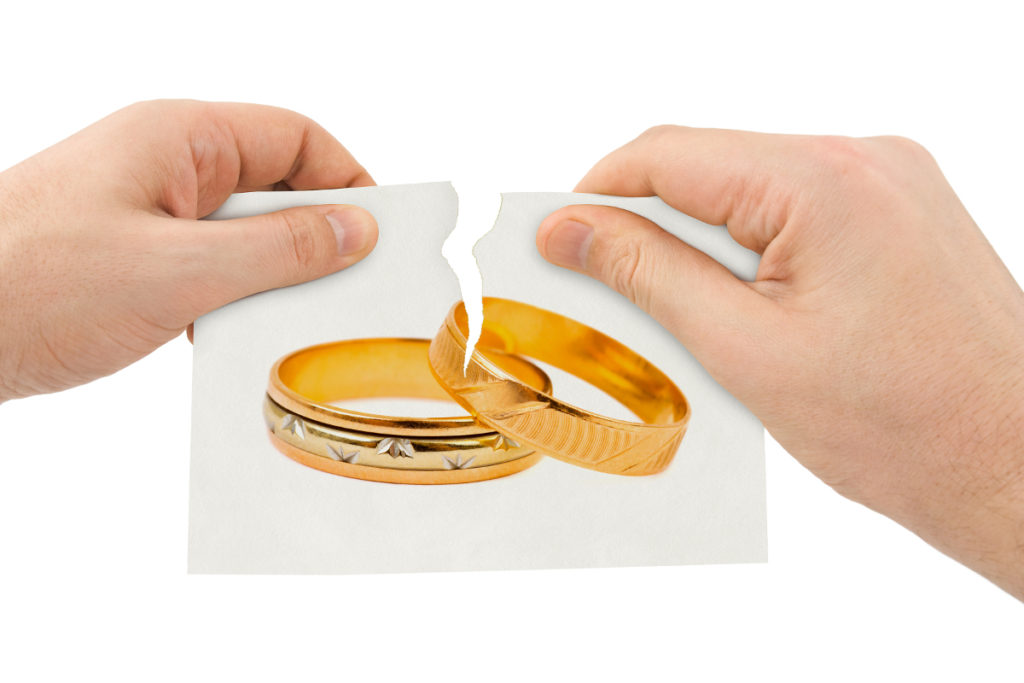 Hands tear picture with wedding rings isolated on white background