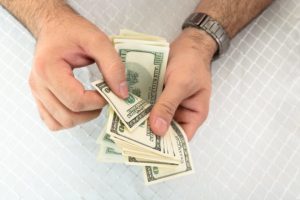 male hands counting money for bail