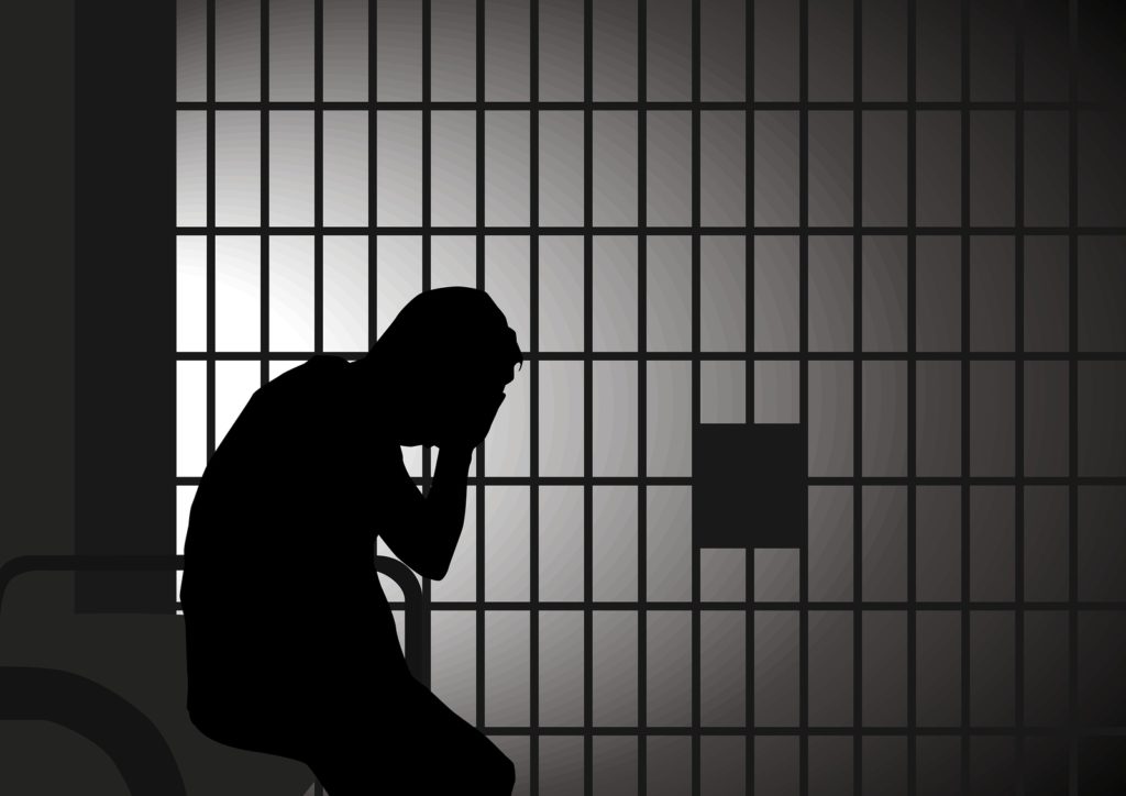 silhouette of depressed prisoner in jail
