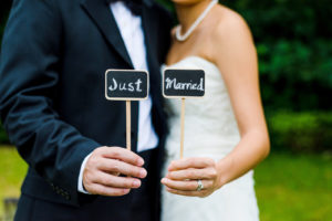 newlywed couple holding up a "just married" sign